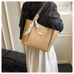 Détail du sac fourre-tout bicolore avec texture litchi et accessoire de foulard imprimé