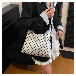 Detail of printed canvas hobo bag showing the classic black and white polka dot pattern