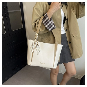 Détail d'un sac cabas bicolore avec texte FASHION et accessoire foulard en soie décoratif