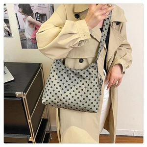 Polka dot crossbody bag styled with a khaki trench coat for a casual autumn fashion look