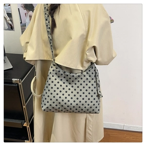 Detailed macro view of gray polka dot canvas hobo bag with wide shoulder strap design