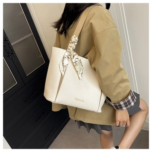 Dettaglio borsa tote in pelle martellata bianco crema con foulard e scritte dorate
