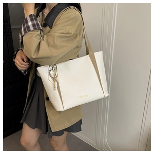 Détail du sac cabas en cuir crème avec contraste kaki, logo et foulard en soie décoratif