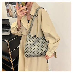 Polka dot hobo bag with adjustable wide strap shown on model side profile view