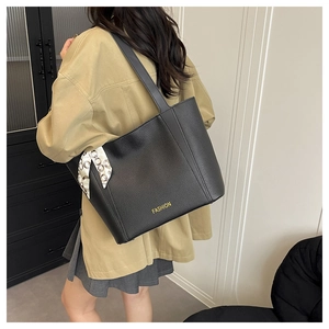 Sac fourre-tout noir avec texture litchi porté à l'épaule et foulard en soie décoratif