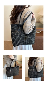 Detail of black and gold tweed tote bag with woven texture and long shoulder straps