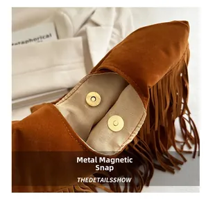 Detail view of the secure magnetic hardware buckles on a brown bohemian tassel tote bag