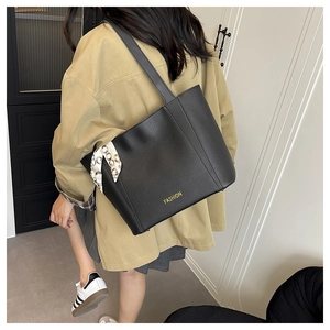 Détail du grand sac cabas noir en cuir grainé avec foulard en soie et logo doré