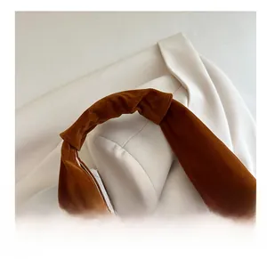 Detail of soft pleated handle on brown suede tote bag showing retro texture and craftsmanship