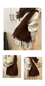 Dettaglio della borsa a spalla in pelle scamosciata marrone scuro con frange boho
