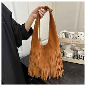 Detail of a brown suede Hobo bag with long bohemian tassels and a knotted handle