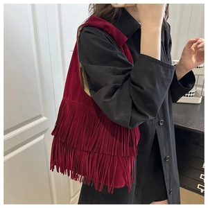 Close-up of a burgundy fringe tote bag with velvet texture and boho tassel design details
