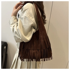 Dettaglio borsa tote in pelle scamosciata marrone con lunghe frange bohémien e tracolla