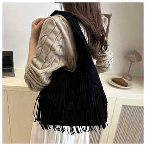 Vista dettagliata della borsa hobo nera con frange, texture scamosciata e nappe