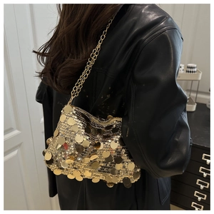 Detail shot of a shimmering gold sequin handbag featuring a metallic gold chain strap