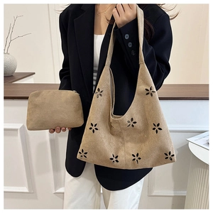 Détail du sac hobo en daim kaki avec motifs floraux découpés au laser et petite pochette