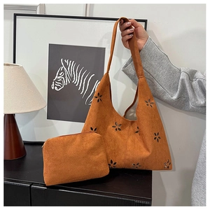 Détail du sac cabas en daim camel avec motifs floraux découpés au laser et pochette