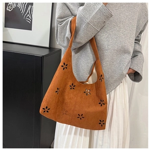 Détail du sac cabas en daim marron avec motifs floraux découpés au laser et large bandoulière