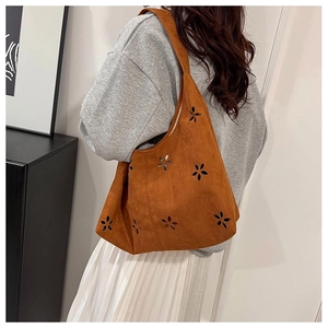 Sac fourre-tout en daim marron avec des motifs floraux découpés au laser sur la bandoulière
