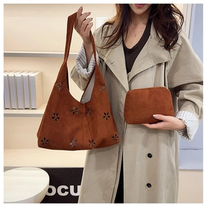 Détail du sac cabas en daim marron rouge avec découpes florales et pochette assortie