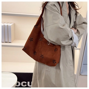 Détail du sac Hobo en daim marron avec motifs floraux découpés au laser