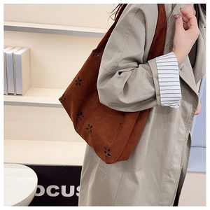 Grand sac fourre-tout en daim marron avec fleurs découpées porté à l'épaule pour femme