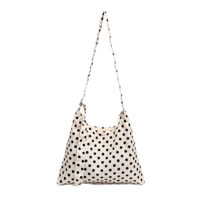 Minimalist cream tote bag with black polka dots featuring top zipper and long shoulder straps