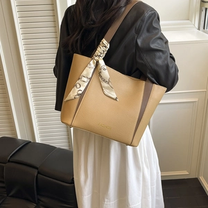 Sac fourre-tout kaki en cuir grainé avec foulard en soie porté par un mannequin chic