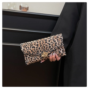Detail of leopard print envelope clutch featuring a gold irregular metal lock fastener