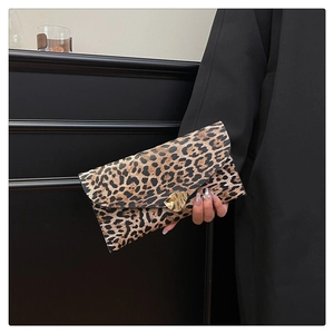 Detail of leopard print envelope clutch featuring a gold heart buckle and magnetic closure