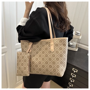 Detail of a beige jacquard tote bag set with geometric patterns and leather handles