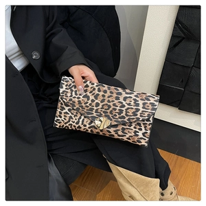 Detail of leopard print clutch featuring a gold heart-shaped metal twist lock closure