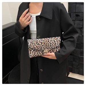 Detail of leopard print clutch featuring a gold heart-shaped twist lock on faux leather
