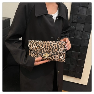 Detail shot of leopard print envelope clutch featuring an irregular gold geometric buckle