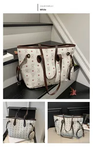 Détail du grand sac cabas blanc à motifs d'ours et mini pochette sur un escalier