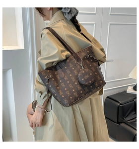 Detail of bear monogram tote bag with matching round pouch charm on model's shoulder