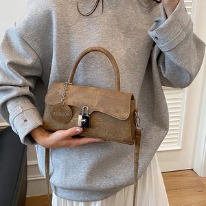 Retro brown faux leather shoulder bag with metallic lock and Fashion tag on a model