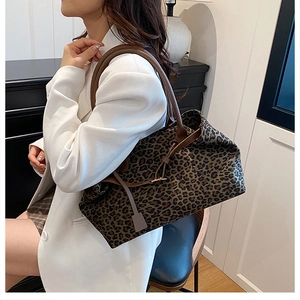 Chic leopard print tote bag with brown leather straps shown on model for daily style