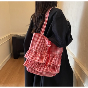 Detail view of red gingham tote bag featuring sweet tiered ruffle layers and drawstring closure