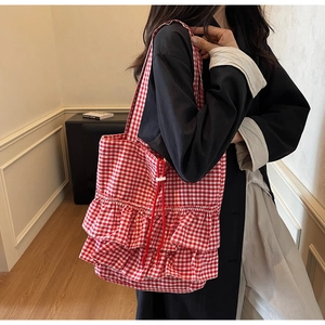 Detail of red and white gingham tote bag featuring aesthetic ruffled layers and drawstring