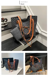 Détail du sac cabas noir avec imprimé trèfle, nœud décoratif et pochette assortie