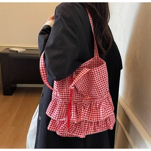 Detail of red and white plaid tote bag with stylish double-layered ruffle design