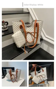 Détail du cabas blanc à monogramme avec lanières en cuir et pochette assortie