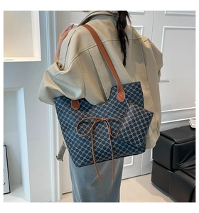 Détail du set cabas vintage avec nœud en cuir marron et mini pochette assortie