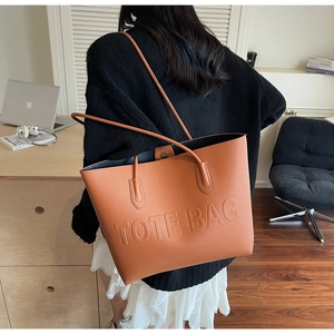 Close-up of brown faux leather tote bag with embossed Tote Bag text for daily use