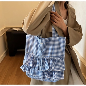 Detailed blue and white gingham tote bag with double ruffles shown on person