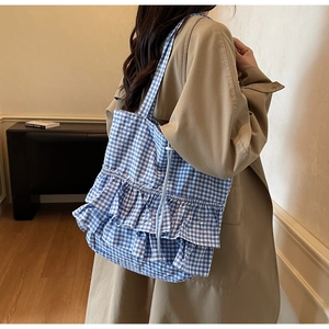 Detailed close-up of blue gingham tote bag featuring triple-layered ruffle accents