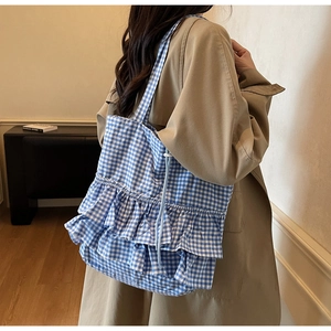 Detail of blue and white gingham tote bag with ruffled layers and drawstring closure