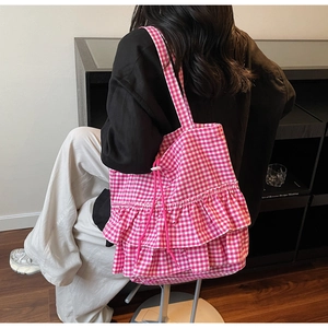 Close-up of pink gingham tote bag featuring layered ruffles and functional drawstring details