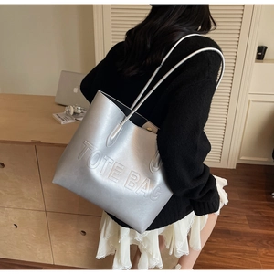 Close-up of metallic silver tote bag with embossed lettering for a modern fashion look
